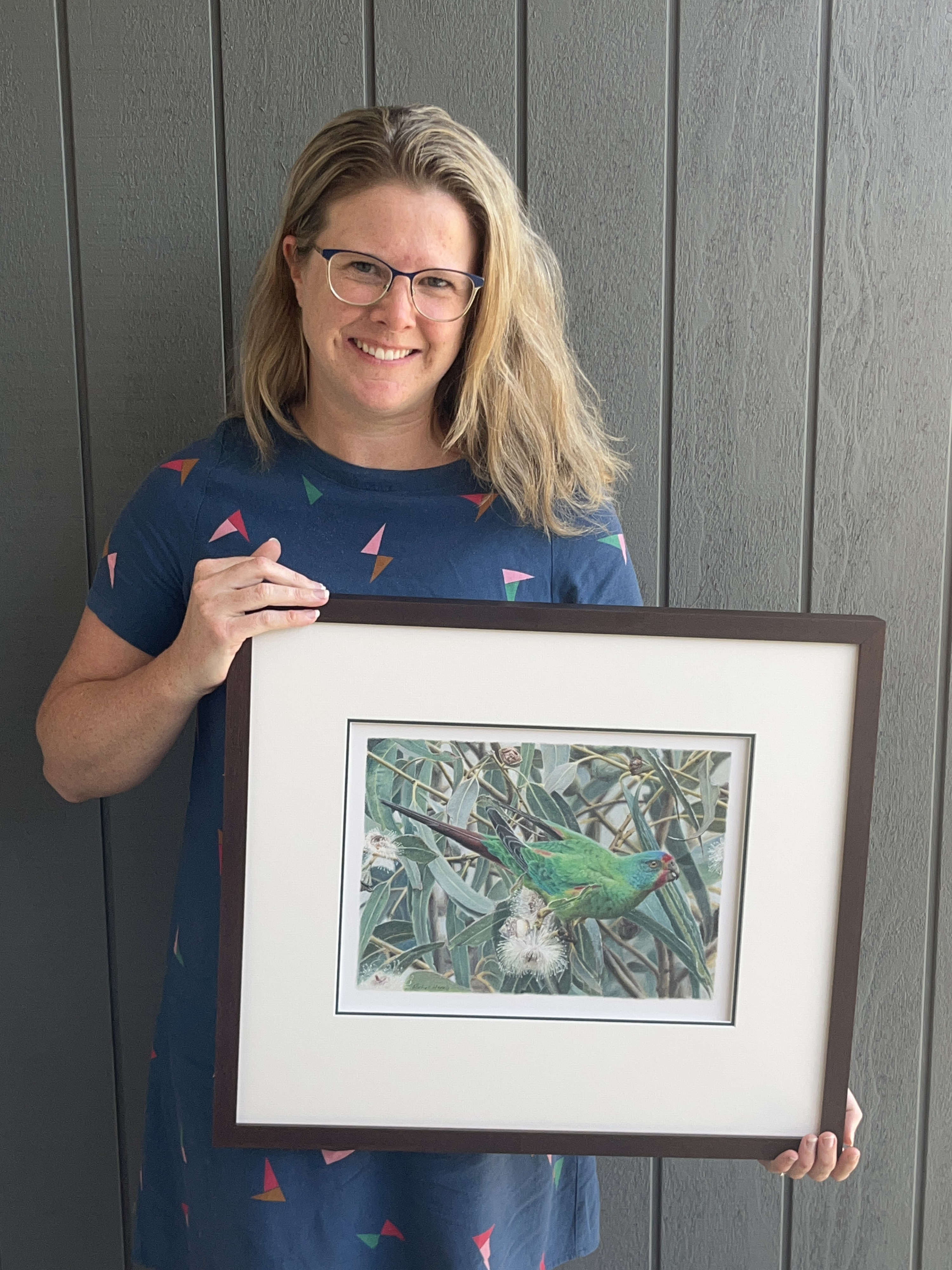Rachel Harris with her drawing of a swift parrot.